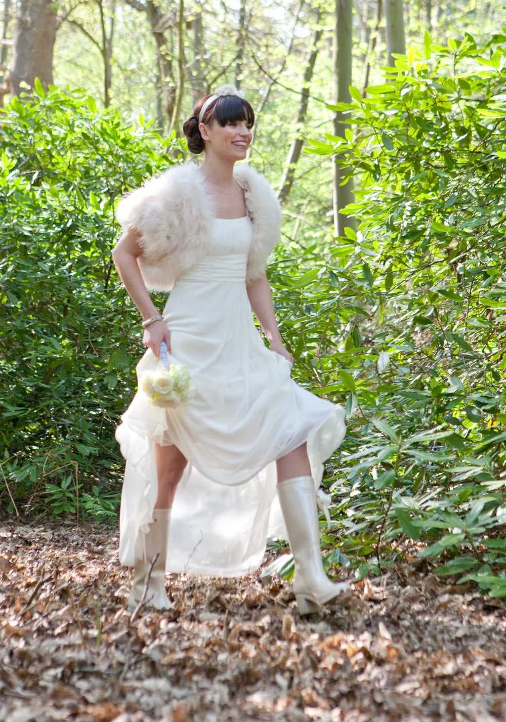 bride walking through the park wearing wedding wellies